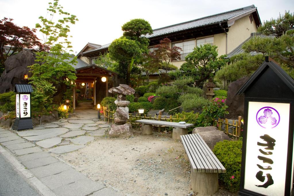 um jardim com um banco em frente a um edifício em Kikori em Fuefuki