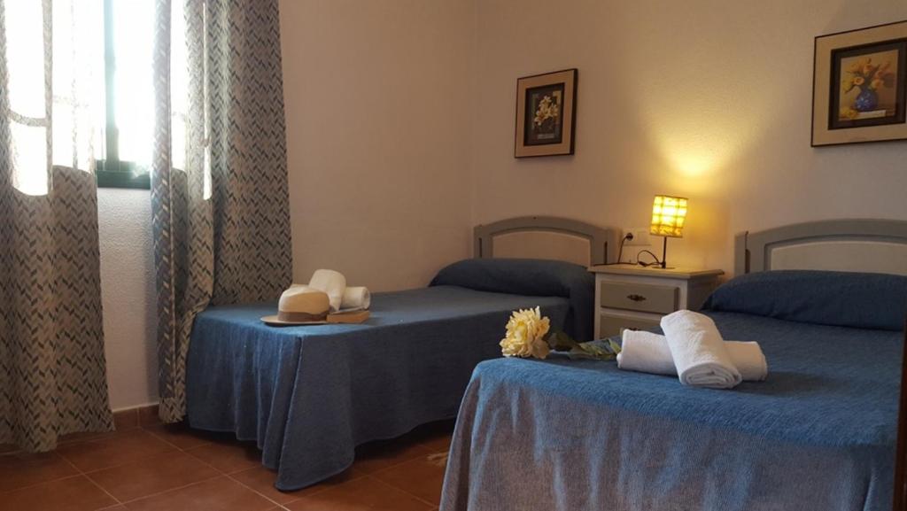 コニル・デ・ラ・フロンテーラにあるChalet Las Adelfas Chaparrilloの青いシーツが備わるベッド2台付きの部屋