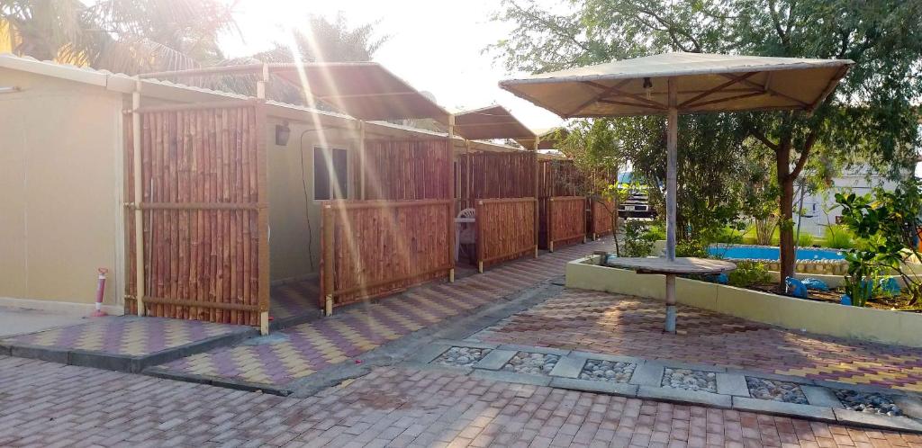 a patio with an umbrella in front of a house at Divers home in Ras al Khaimah