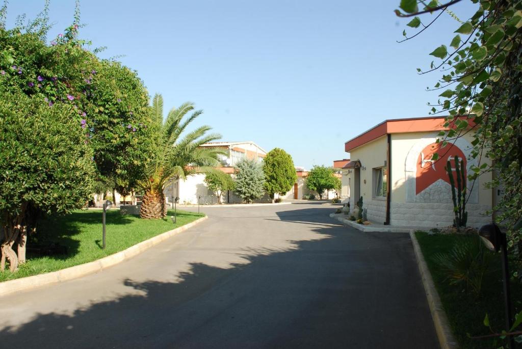 una calle en un pueblo con un edificio y árboles en Hotel Giardino, en Modugno