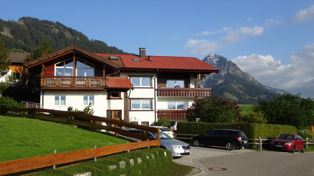 a house with cars parked in front of it at Ferienwohnungen Rotzler in Oberstdorf
