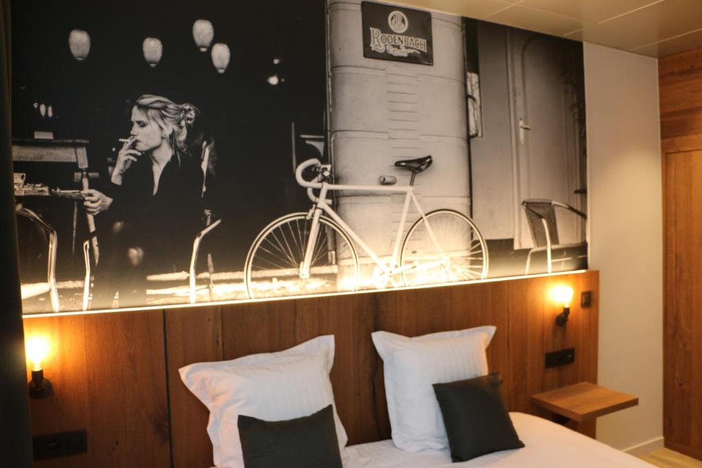 Dormitorio con póster de bicicleta en la pared en Hotel Botteltje en Ostende