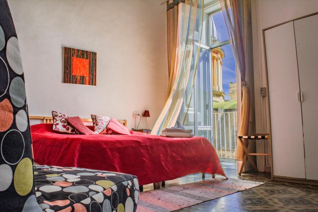 ナポリにあるB&B Teclaのベッドルーム(赤いベッド1台、バルコニー付)