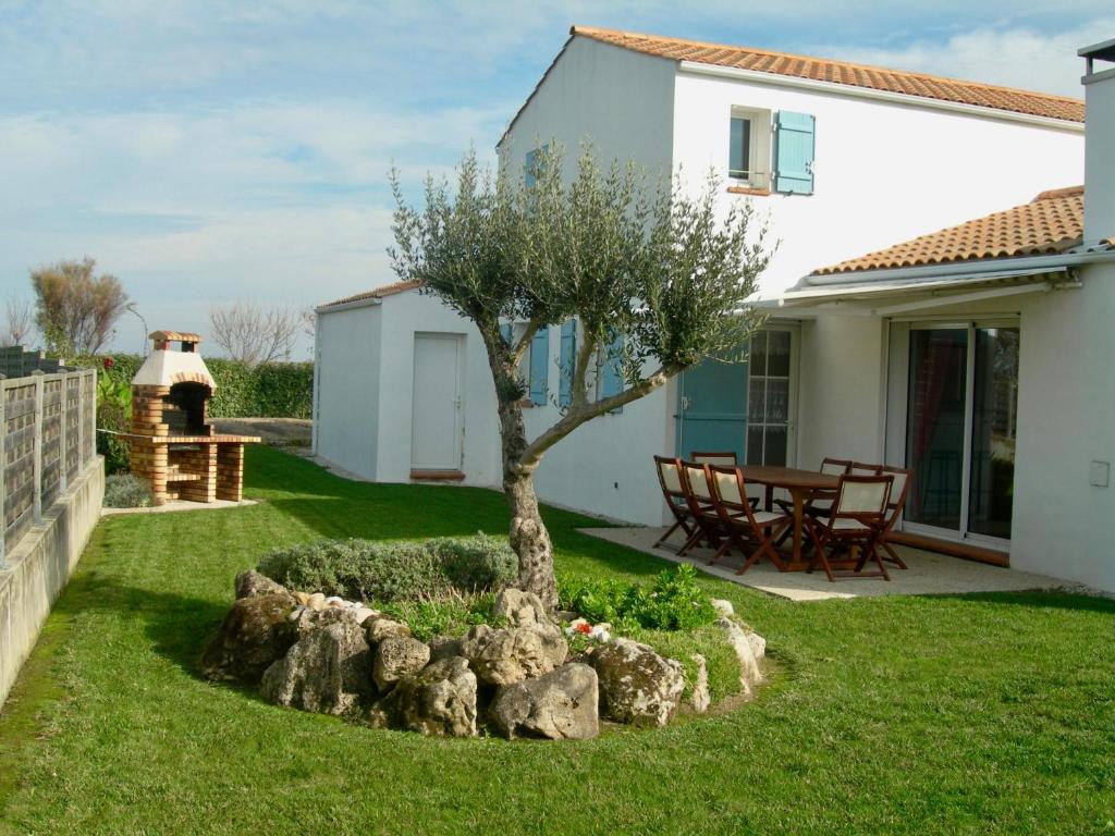 La Guérinière的住宿－Maison idéale pour des vacances au cœur de l’Ile de Noirmoutier，房子院子中的一棵树