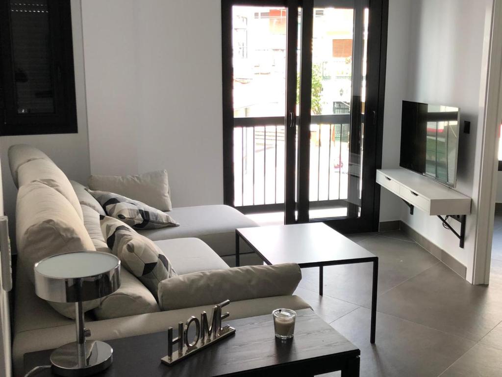 uma sala de estar com um sofá e uma mesa em Apartamentos Kronox em Nerja