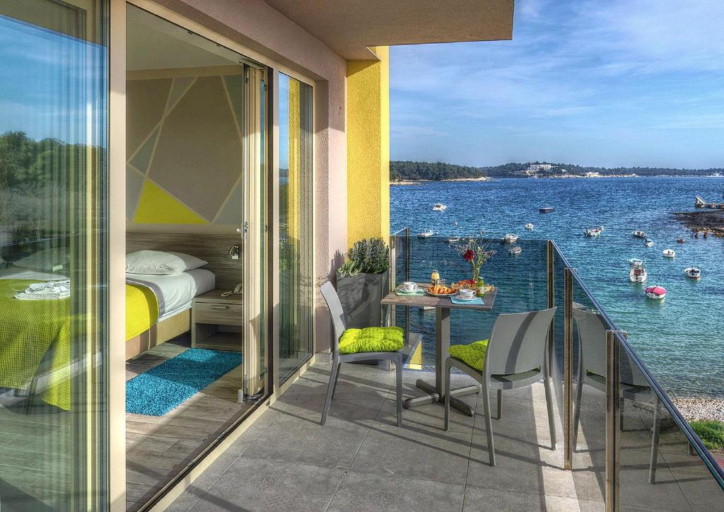 a balcony with a bed and a view of the water at Hotel Modo in Pula