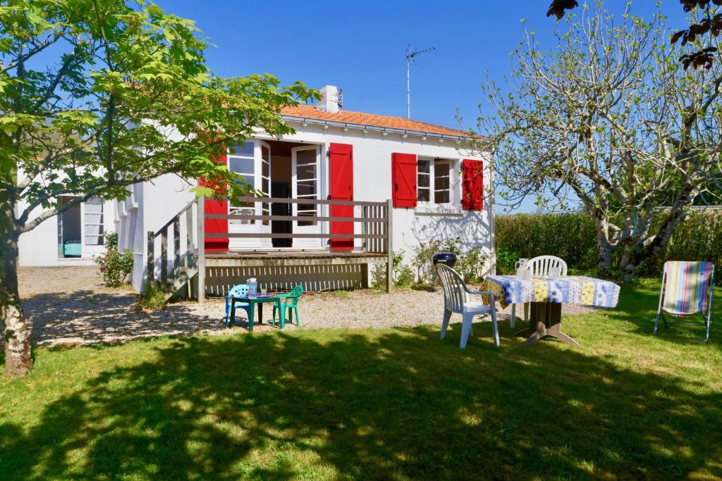 une maison avec une table et des chaises devant dans l'établissement Maison de vacances à 2 pas de la plage du Portmain, à Pornic