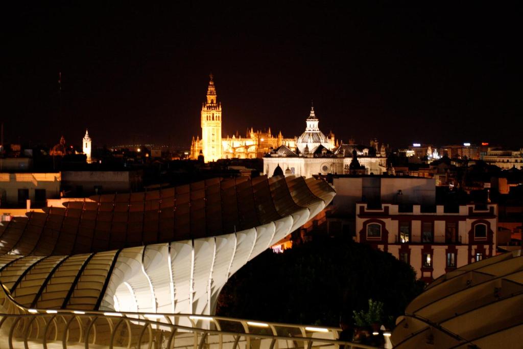 a view of a city at night with a bridge at Hotel Palace Sevilla in Seville
