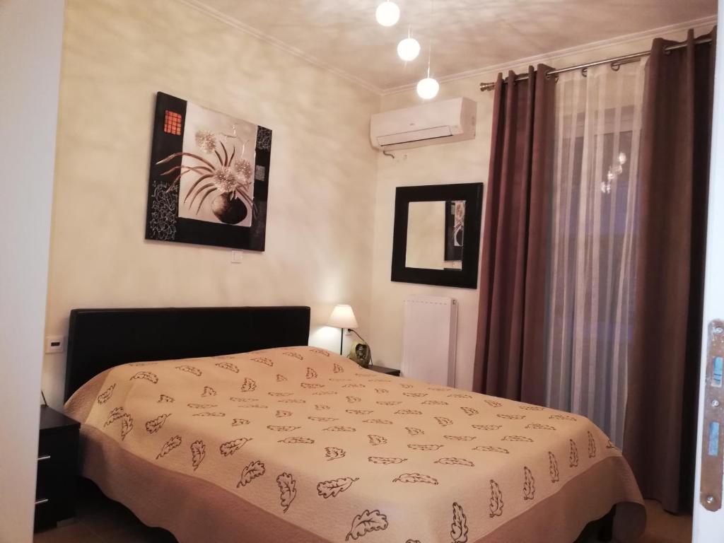 a bedroom with a bed and two pictures on the wall at Efi Apartment in Paralio Astros