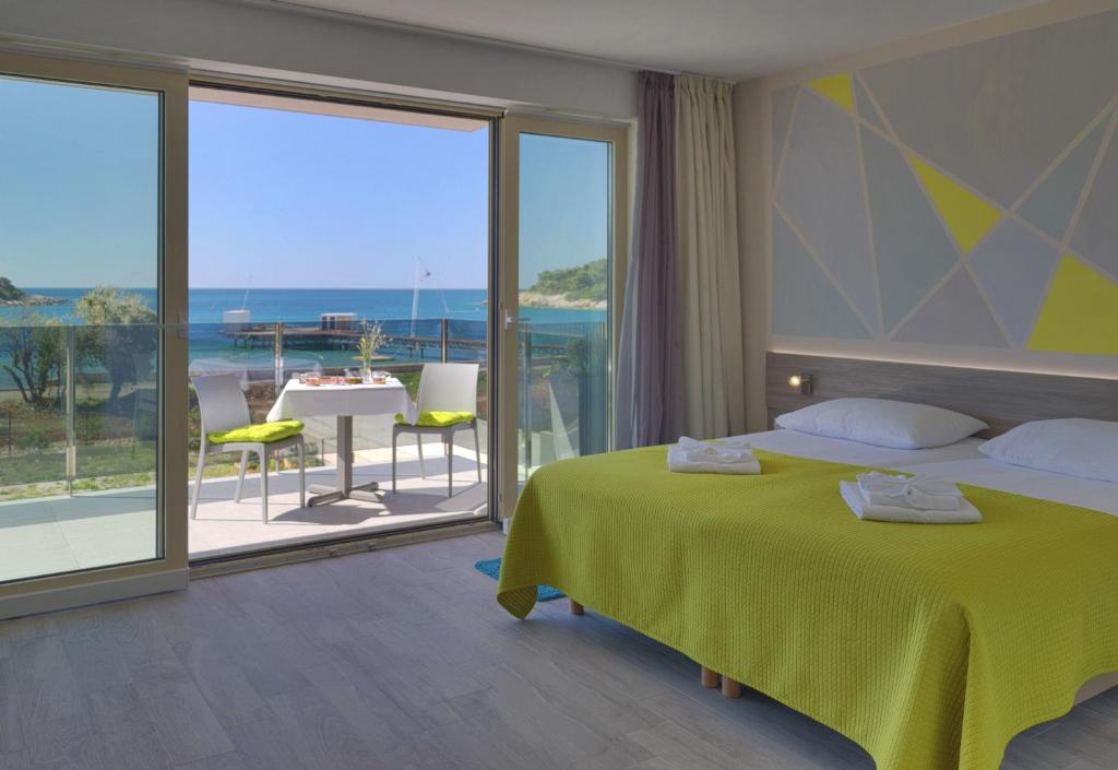 a hotel room with a bed, chair, and table at Hotel Modo in Pula