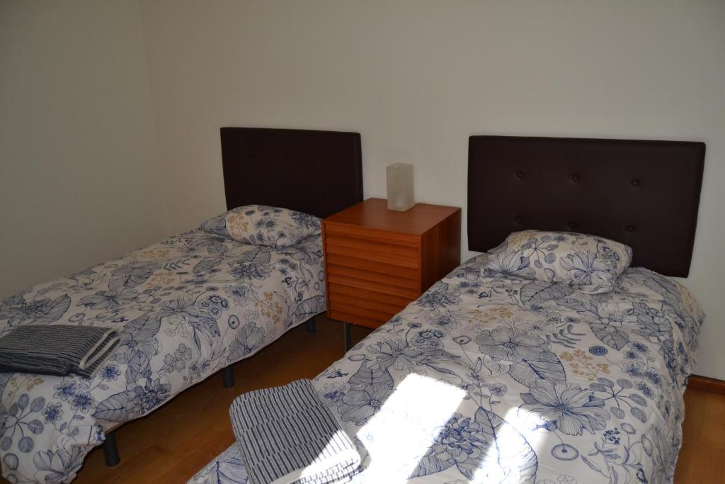 a bedroom with two beds and a dresser and a table at Precioso apartamento Centro de Sevilla in Seville