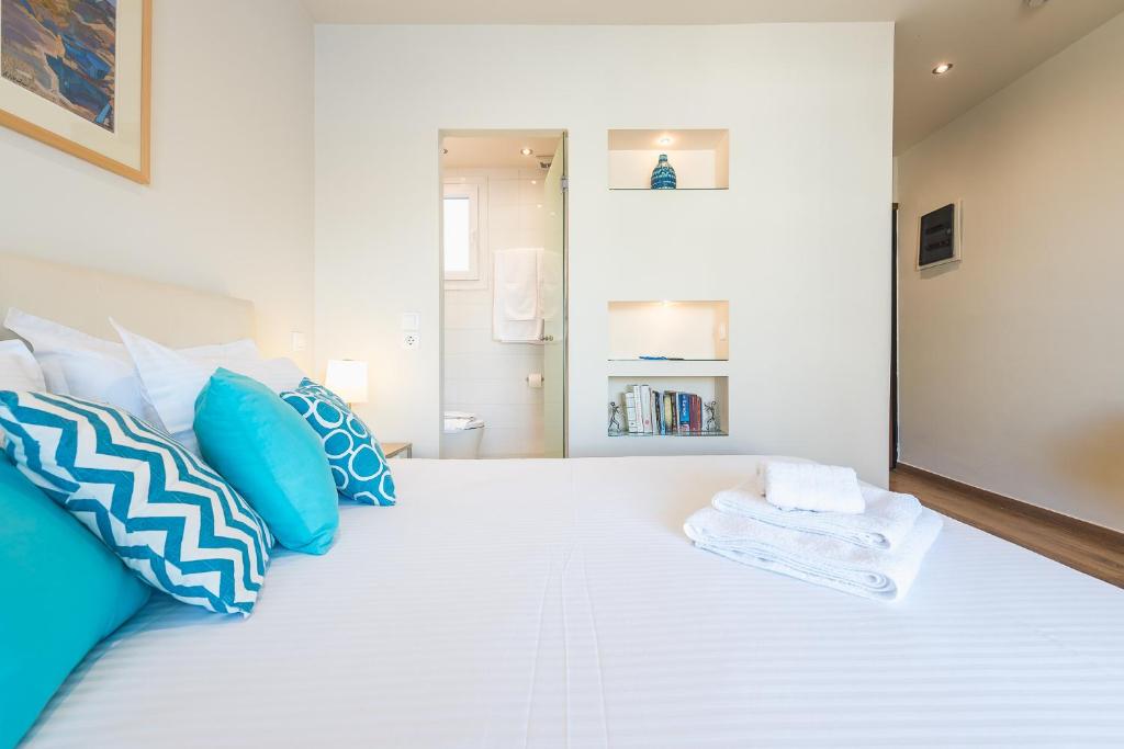 a bedroom with a large white bed with blue pillows at Stunning Acropolis view at City Center in Athens