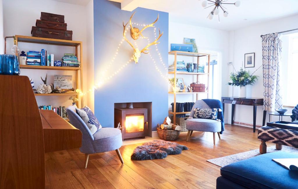 a living room with a fireplace and blue walls at Bell Lodge in Chichester