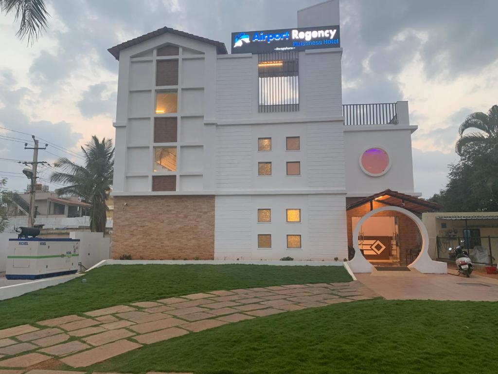 a large white building with a sign on top of it at Airport Regency in Devanahalli-Bangalore