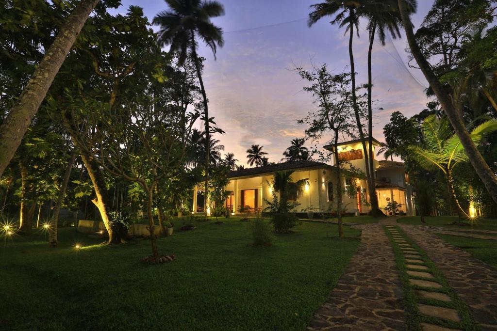 a house with a garden at night with lights at Amara Villa in Galle
