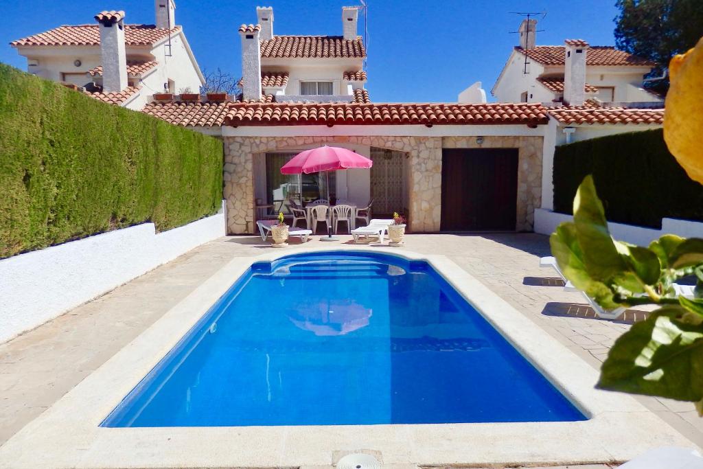 a swimming pool in front of a house at MEDDAYS VILLA HORUS CON PISCINA PRIVADA in Miami Platja