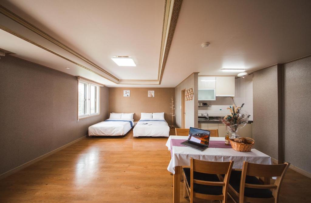 a room with a table and a bed and a kitchen at Jungmun Resort Jeju in Seogwipo