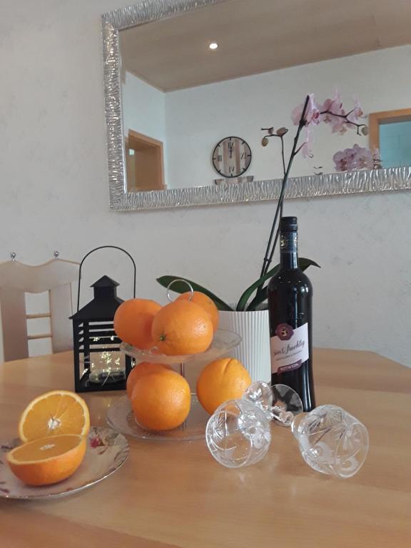 una mesa con naranjas y una botella de vino en Ferienwohnung Wagner en Zweibrücken