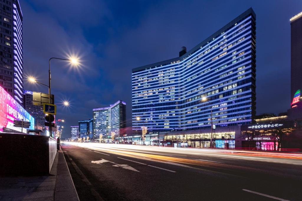 eine Stadtstraße in der Nacht mit Gebäuden und Straßenbeleuchtung in der Unterkunft Pentahotel Moscow, Arbat in Moskau