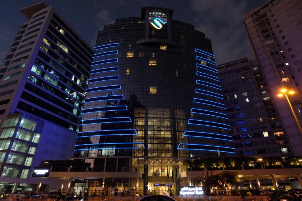 a tall building with a clock on top of it at Signature 1 Hotel Tecom in Dubai