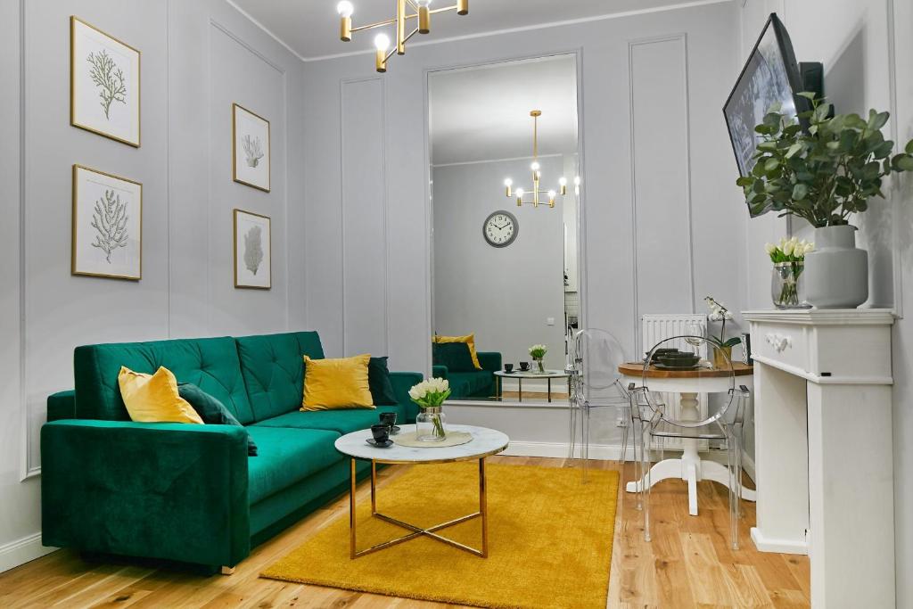 a living room with a green couch and a table at Stara Praga Vistula Apartment in Warsaw