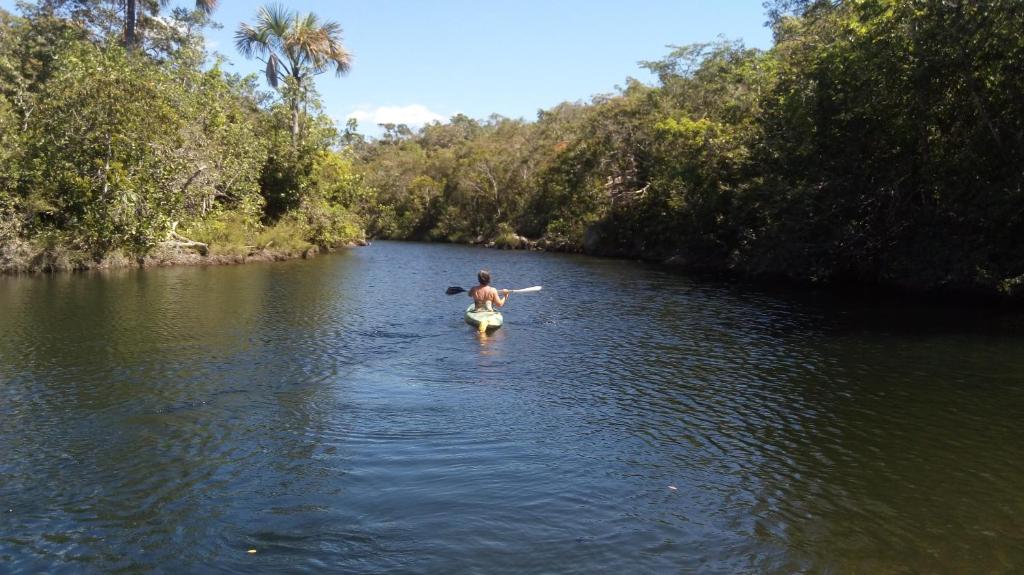 un hombre está caminando en un río en el agua en Pousada Aldeia Cayana, en Cavalcante