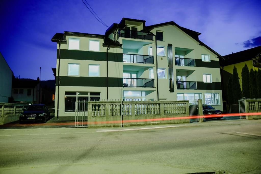 duży budynek apartamentowy z ogrodzeniem przed nim w obiekcie Deluxe apartments w Sarajewie