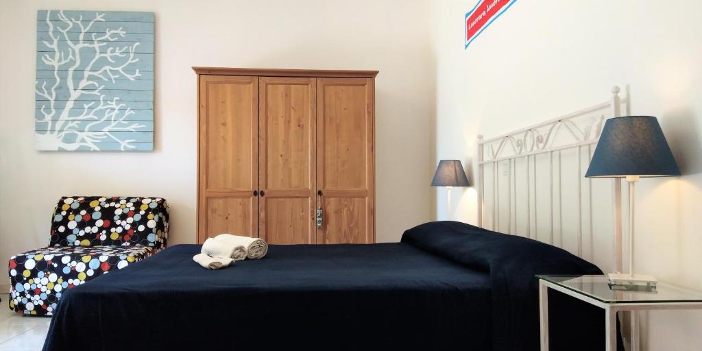 um quarto com uma cama azul e uma cadeira em Brezza Marina Studios em Montesilvano