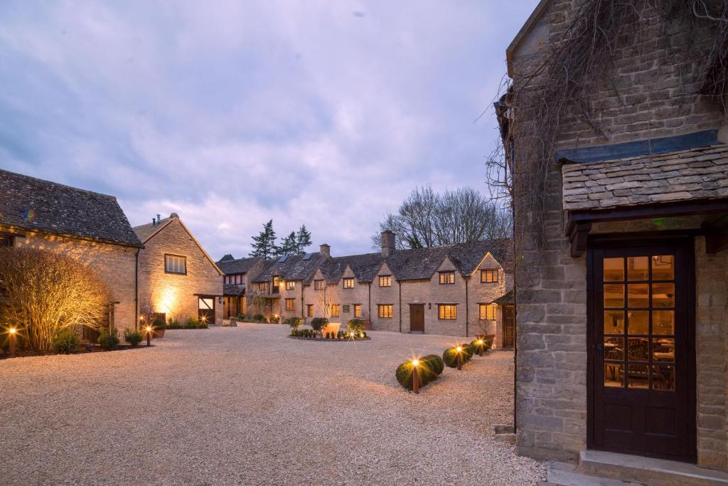 a row of brick houses with lights on a driveway at Minster Mill Hotel in Minster Lovell