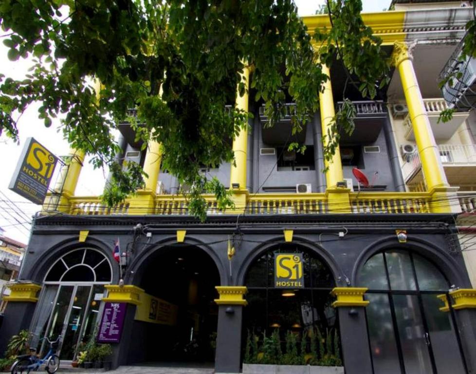een geel en zwart gebouw met een winkel bij S1hostel Bangkok in Bangkok