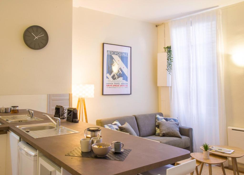 uma cozinha e sala de estar com um sofá em Le Saint Nicolas by Cocoonr em Toulouse
