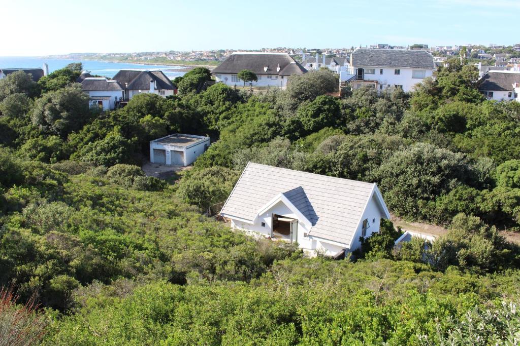 a white house on a hill with houses at St Francis Cottage close to beach in St Francis Bay