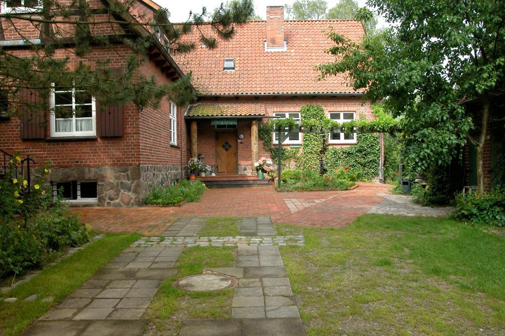 a brick house with a door and a yard at Privatzimmer Alte Schule in Suderburg