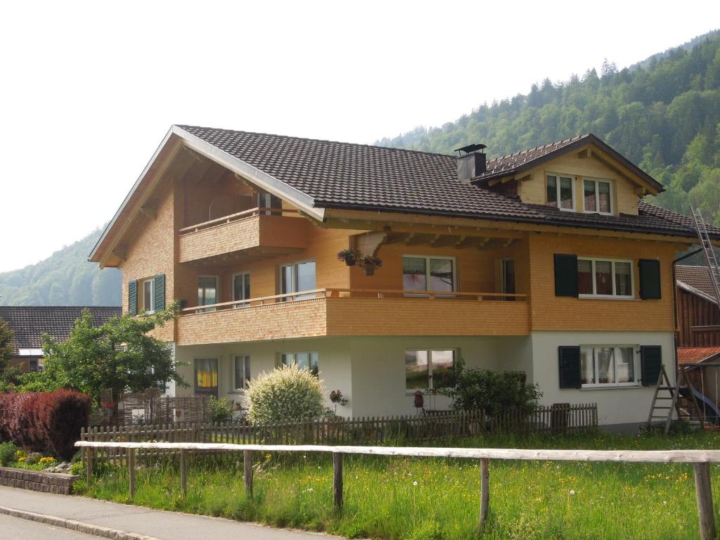 une maison avec une clôture devant elle dans l'établissement Gästehaus Graf, à Bezau