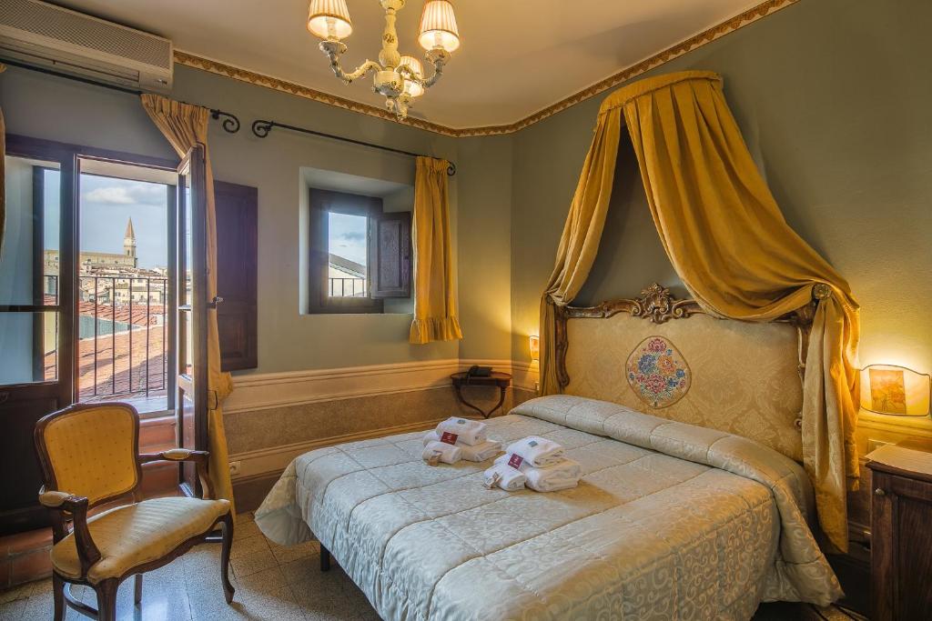 ein Schlafzimmer mit einem Bett mit zwei ausgestopften Tieren darauf in der Unterkunft I Portici Hotel - Residenza D'Epoca in Arezzo