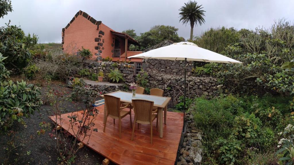 a wooden deck with a table and an umbrella at Gran Drago in Valverde