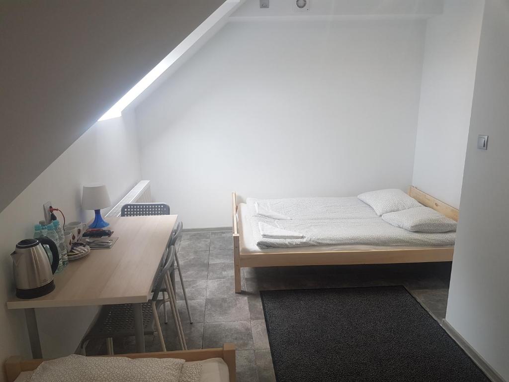 a room with a bed and a desk and a bed and a table at Noclegi u Andrzeja in Gdańsk