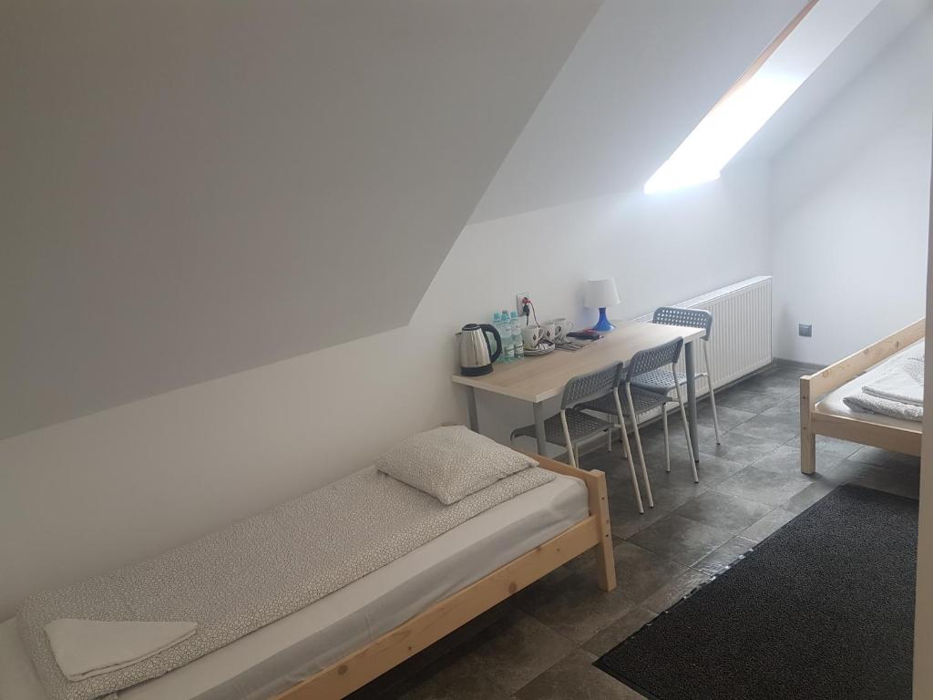 a bedroom with a bed and a table with chairs at Noclegi u Andrzeja in Gdańsk