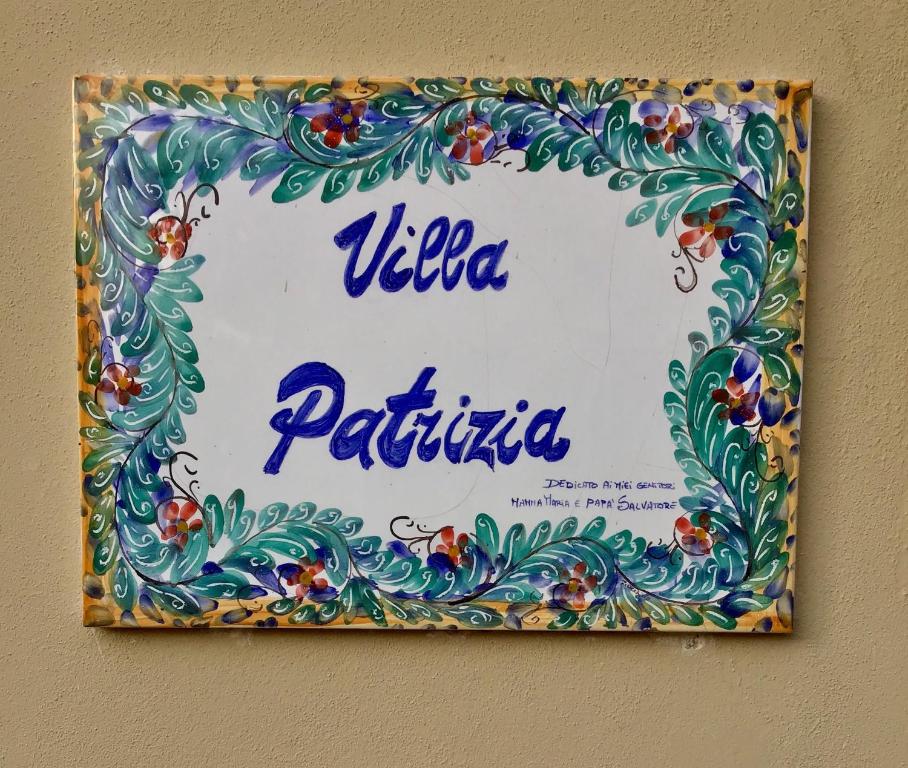 un cartel en una pared que dice vila patricias en Casa Patrizia, en Giardini Naxos