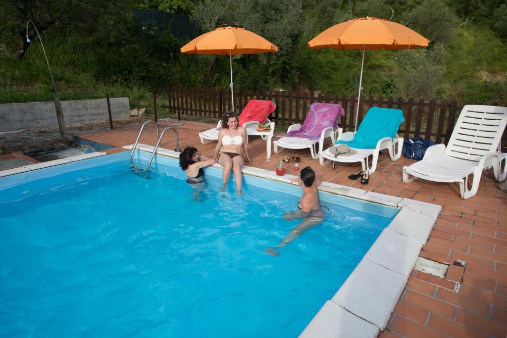 a group of three girls playing in a swimming pool at Fattoria Cristina - Bilo Verde in Castelnuovo Magra
