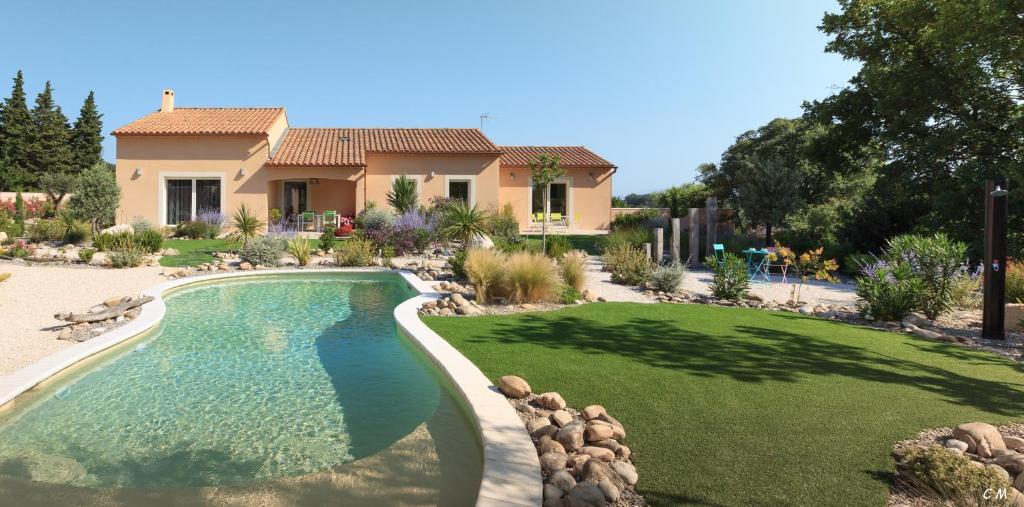 a house with a swimming pool in front of a yard at Martichris in Châteauneuf-de-Gadagne