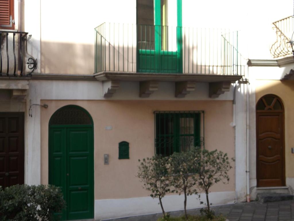 un edificio con puertas verdes y balcón en Via Giuseppe Garibaldi 115 en Lipari