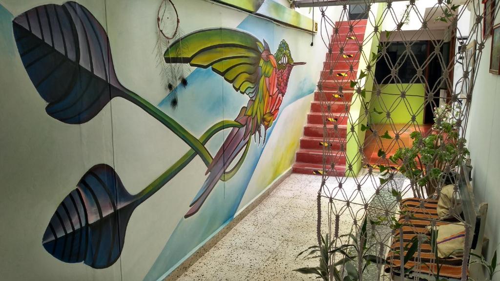 un pasillo con un mural de un pájaro en la pared en Ruta Alterna Backpacker, en Cajamarca