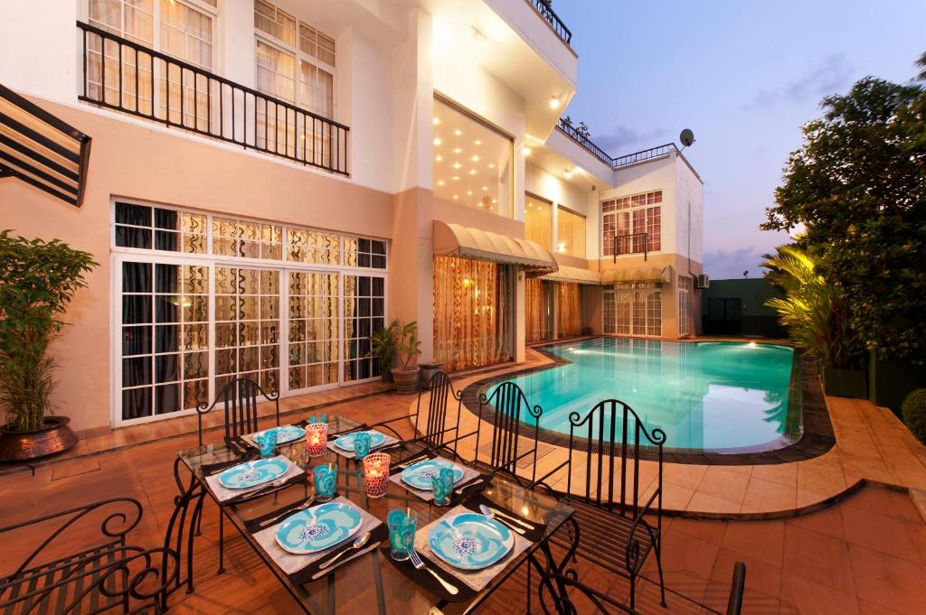 eine Terrasse mit einem Tisch und Stühlen neben einem Pool in der Unterkunft Villa 53 in Battaramulla