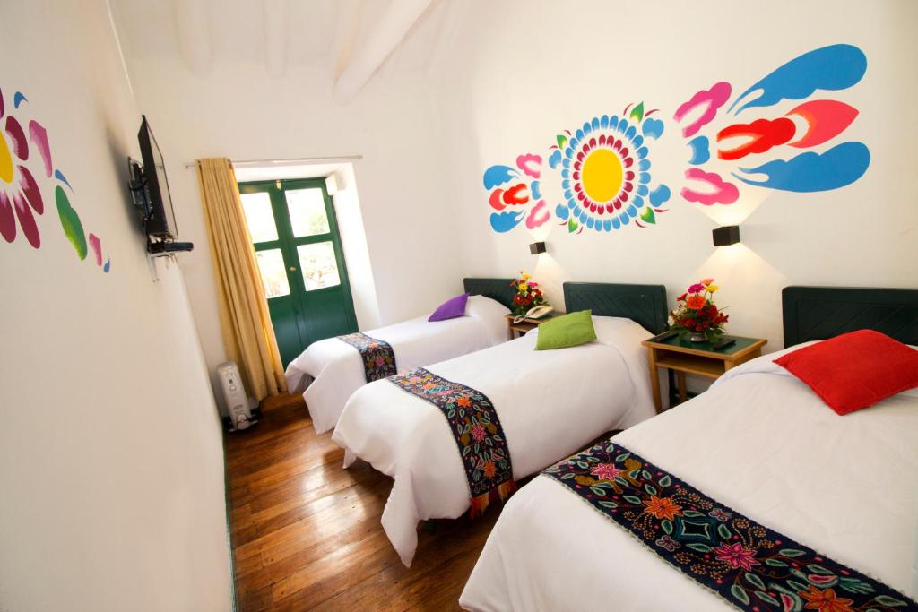 a group of four beds in a room at Cusco Plaza Nazarenas in Cusco
