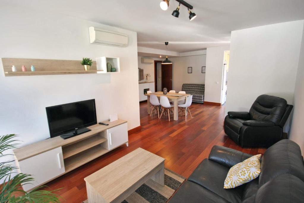 a living room with a couch and a tv and a table at El Mirador de Nabaín in Boltaña