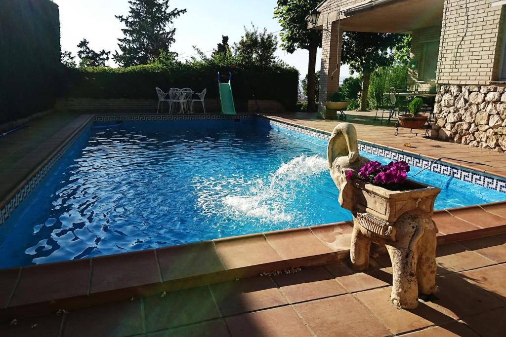 una piscina con un tazón de flores al lado en Villa Las Catalpas en Monachil