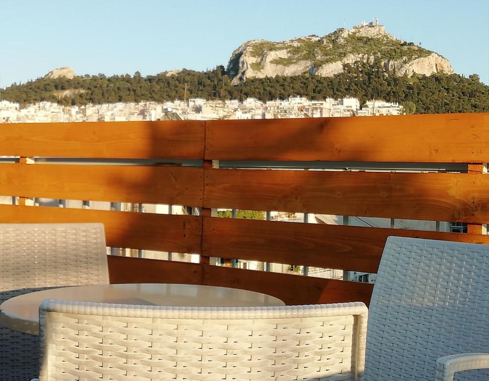 a wooden bench sitting on top of a lush green hillside at Hotel Exarchion in Athens