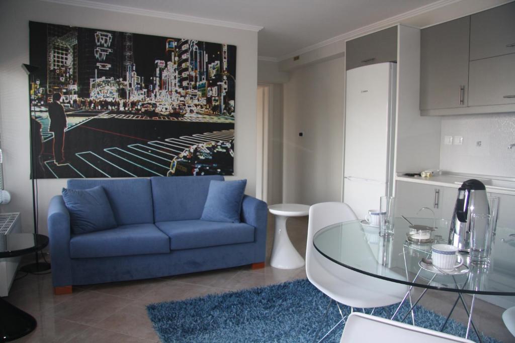 西里阿莫斯的住宿－Thalatta Seaside Accommodation，客厅配有蓝色的沙发和玻璃桌