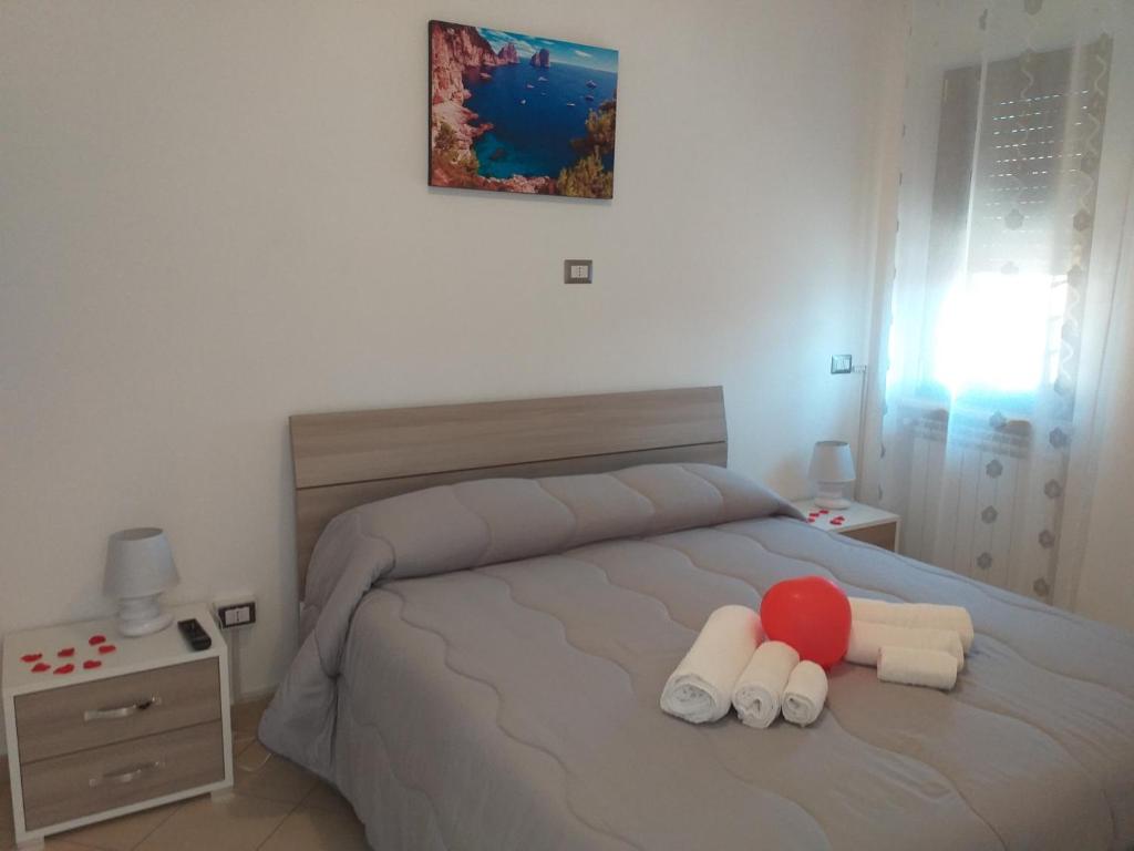 Un dormitorio con una cama con una bola roja. en Appartamento B&B Domus Pompei, en Scafati